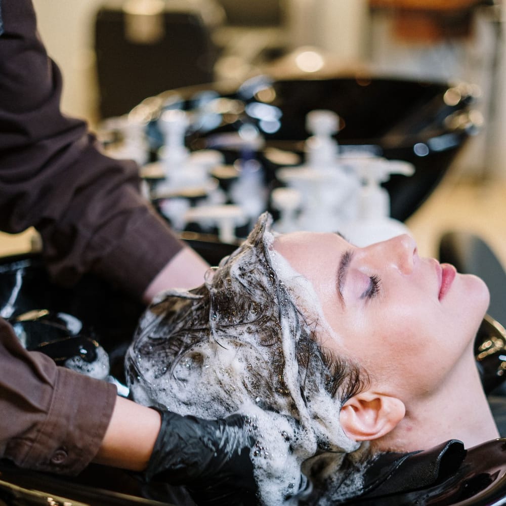 Client receiving a professional hair wash and scalp massage