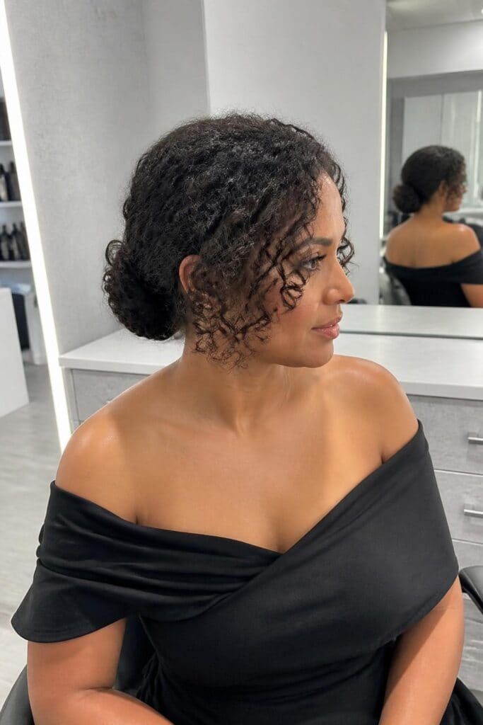 Low Curly Bun with Face-Framing Curls