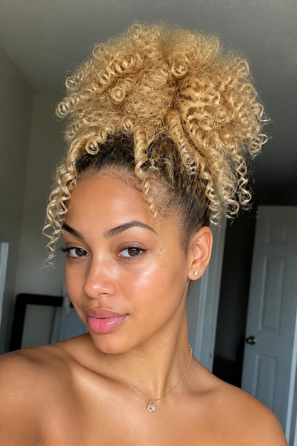 Woman with butter blonde high puff with curls