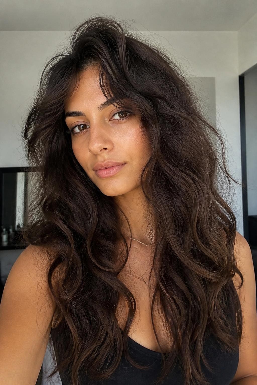 Woman with long layered haircut on frizzy wavy hair with visible frizz