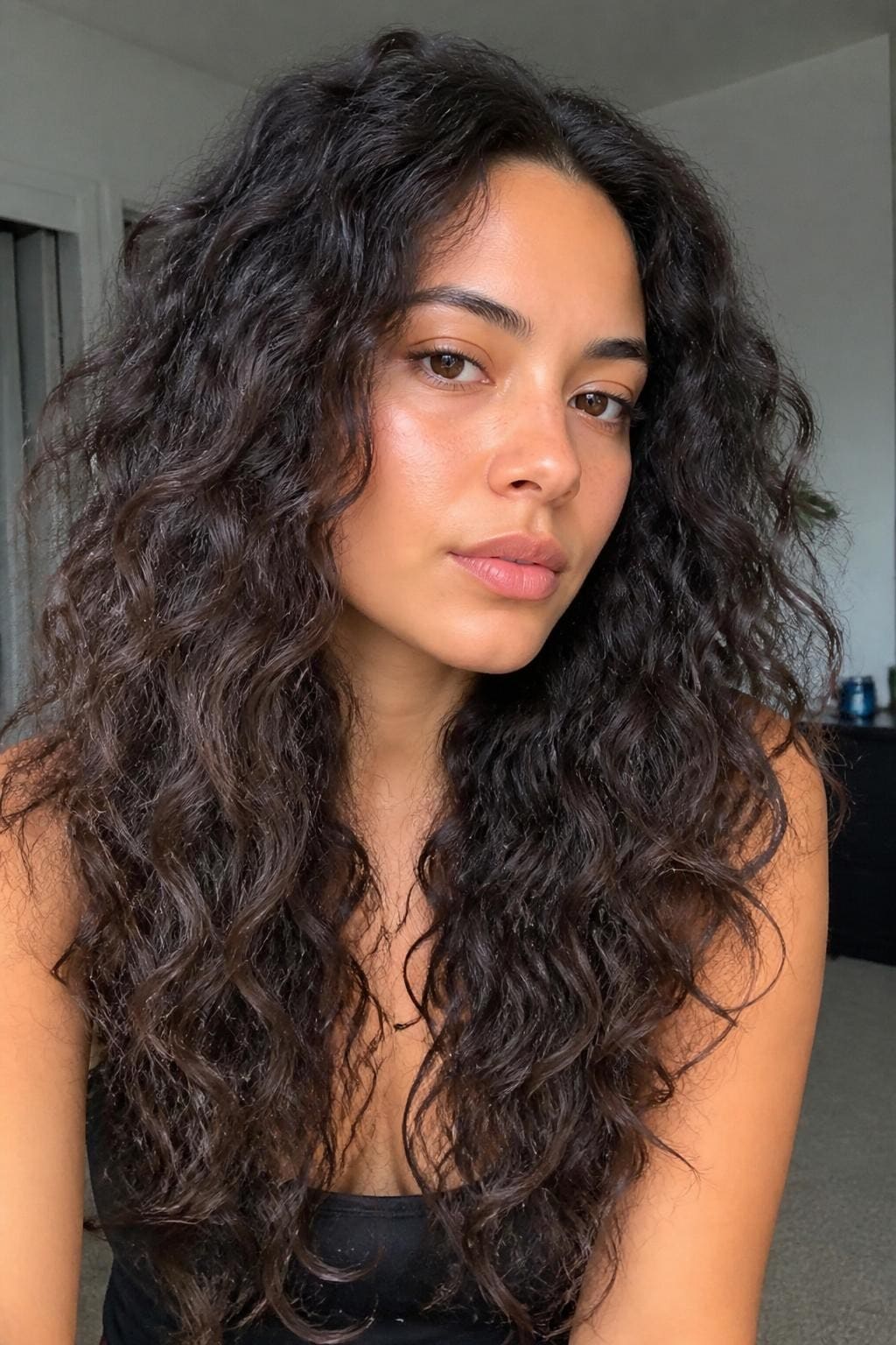 Woman with overnight twist-out waves on frizzy wavy hair, S-pattern not coils